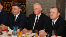 Członkowie Zarządu Województwa Świętokrzyskiego Marek Jońca i Marek Bogusławski siedzą przy stole podczas spotkania opłatkowego z kombatantami