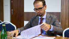 Mężczyzna siedzący przy stole przegląda dokumenty