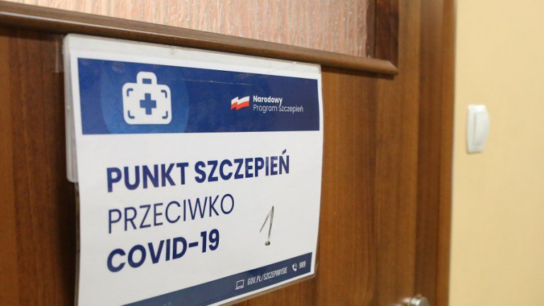 Na drzwiach plansza z napisem Punkt szczepień przeciwko Covid - 19. Narodowy Program Szczepień