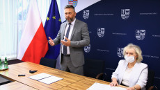 Tomasz Jamka Stoi Za Stołem, Obok Siedzi Za Stołem Dyrektor Renata Bilska.