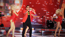 Na scenie występ Czadomana. Śpiewającemu mężczyźnie towarzyszą trzy tancerki ubrane w czerwone kostiumy