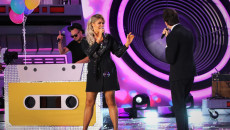 Na scenie śpiewająca kobieta w czarnej sukience i dwóch mężczyzn z mikrofonami. Klawiszowiec gra na syntezatorze, którego obudowa przypomina kasetę magnetofonową w żółtym kolorze. Występ After Party i Camasutra
