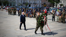 Marszałek Andrzej Bętkowski zbliża się do Pomnika Józefa Piłsudskiego idąc za żołnierzem niosącym wieniec