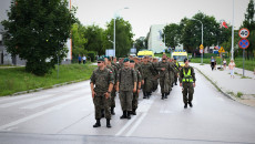 Grupa żołnierzy w mundurach, w tle dwa żółte ambulanse. Oddział Pieszy Uczestników Marszu przy ulicy Krakowskiej w Kielcach