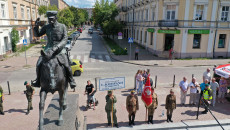 Fotografia z drona. Widok z lotu ptaka na pomnik Marszałka Józefa Piłsudskiego stojący na placu Wolności w Kielcach. Pomnik to konny portret salutującego marszałka. Na dole, obok pomnika, poczet sztandarowy