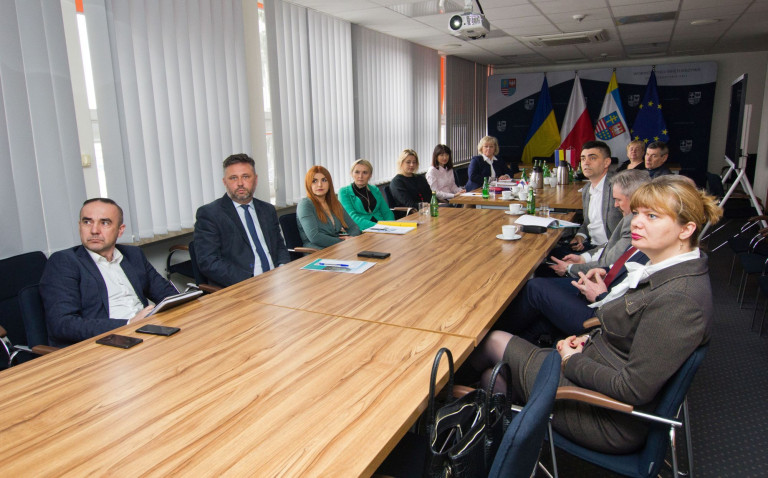 Członek Zarządu Wojeództwa Świętokrzyskiego Tomasz Jamka siedzi przy stole wraz z uczestnikami spotkania