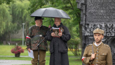 Paweł Krakowiak stoi pod parasolem wraz z księdzem