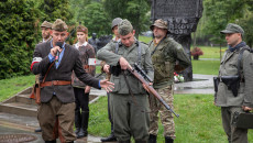 Mężczyźni z grupy rekonstrukcyjnej stoją z bronią w dłoniach